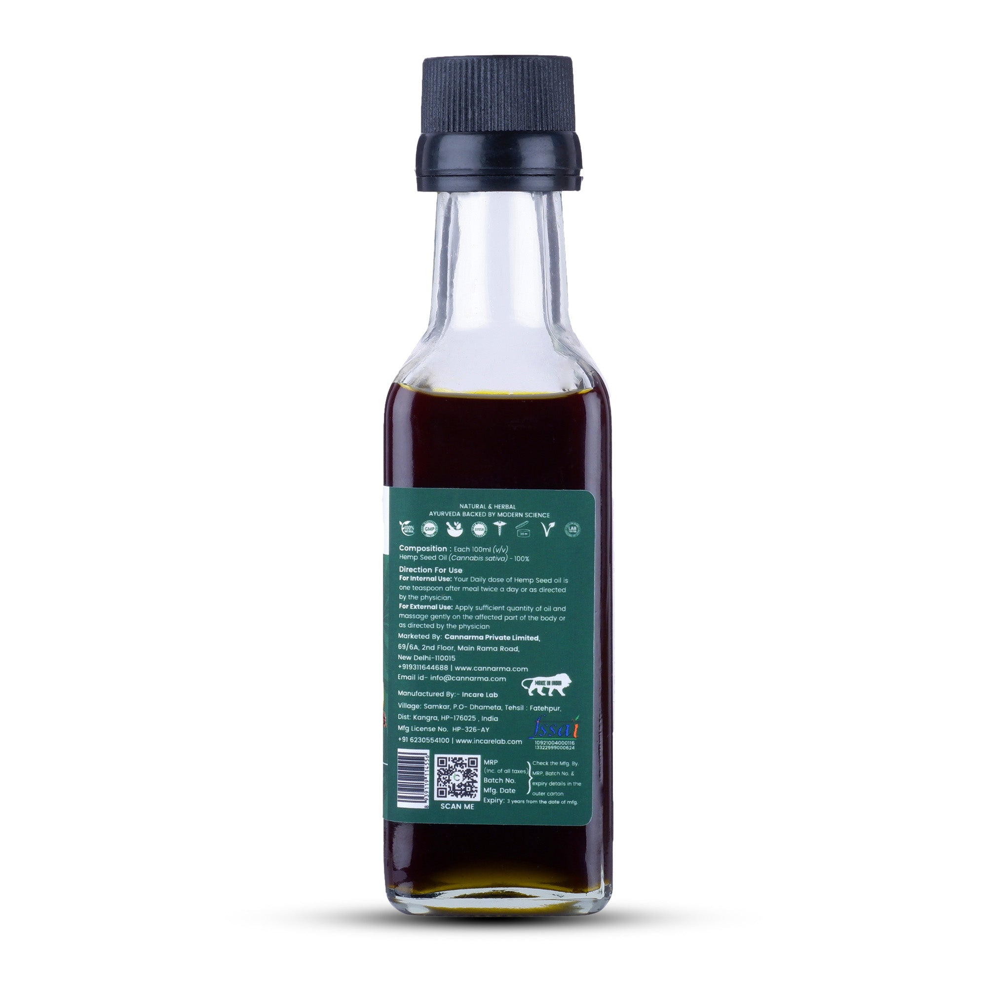 Glass bottle of dark hemp seed oil with green label on white background
