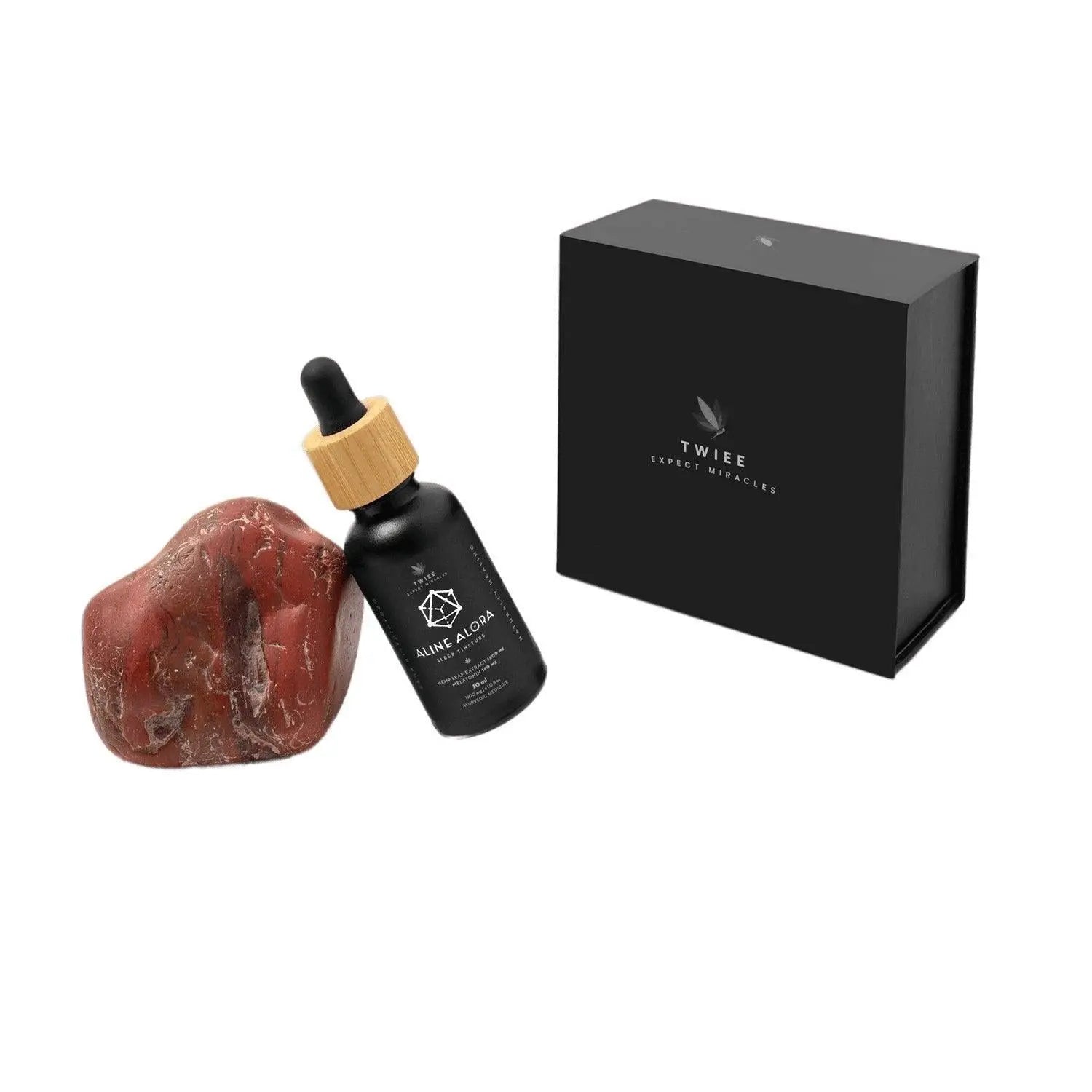 Twiee Aline Alora cannabis sleep tincture bottle next to a red stone and black box.
