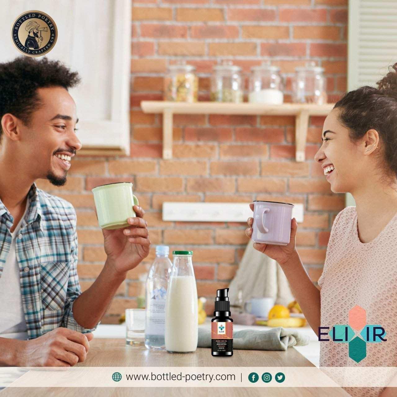 Two people smiling and holding mugs with cbd oil bottle on counter